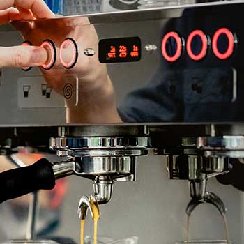 Rot leuchtende Knöpfe einer Siebträgerkaffeemaschine