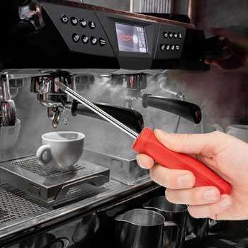 Hand mit Schraubenzieher vor einer Siebträgerkaffeemaschine