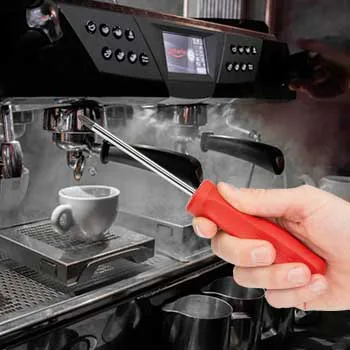 Hand mit Schraubenzieher vor einer Siebträgerkaffeemaschine